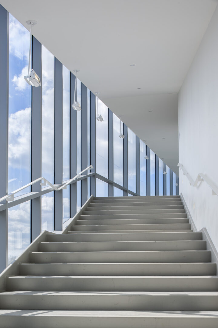 Staircase with glass wall revealing blue sky