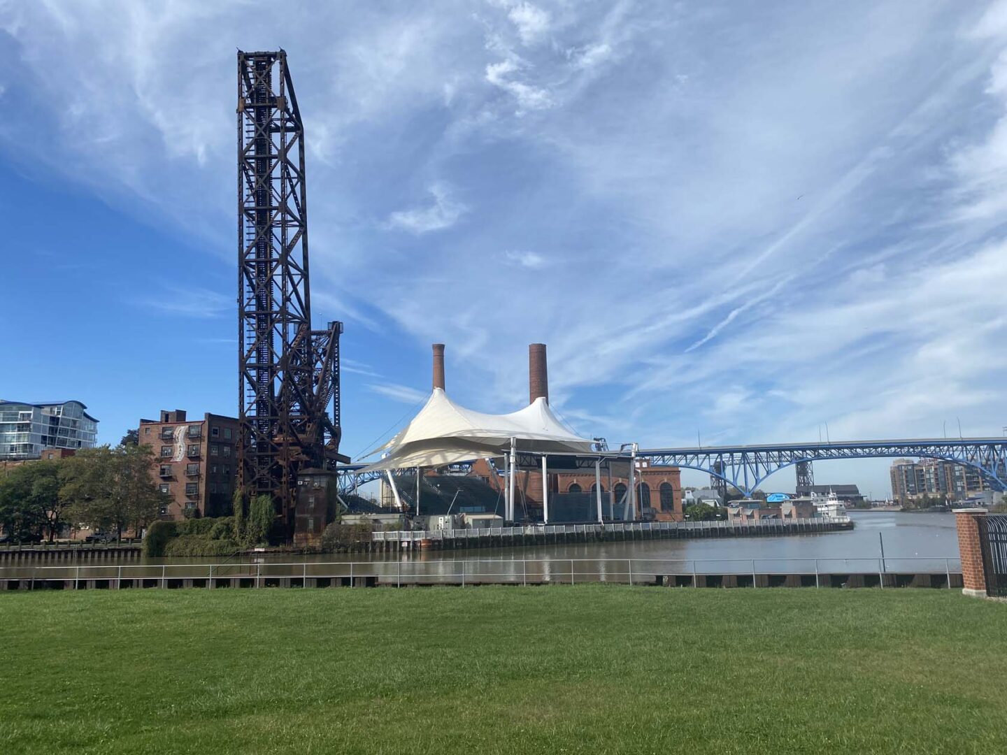 Exterior of open-air riverside performance venue taken from across a park