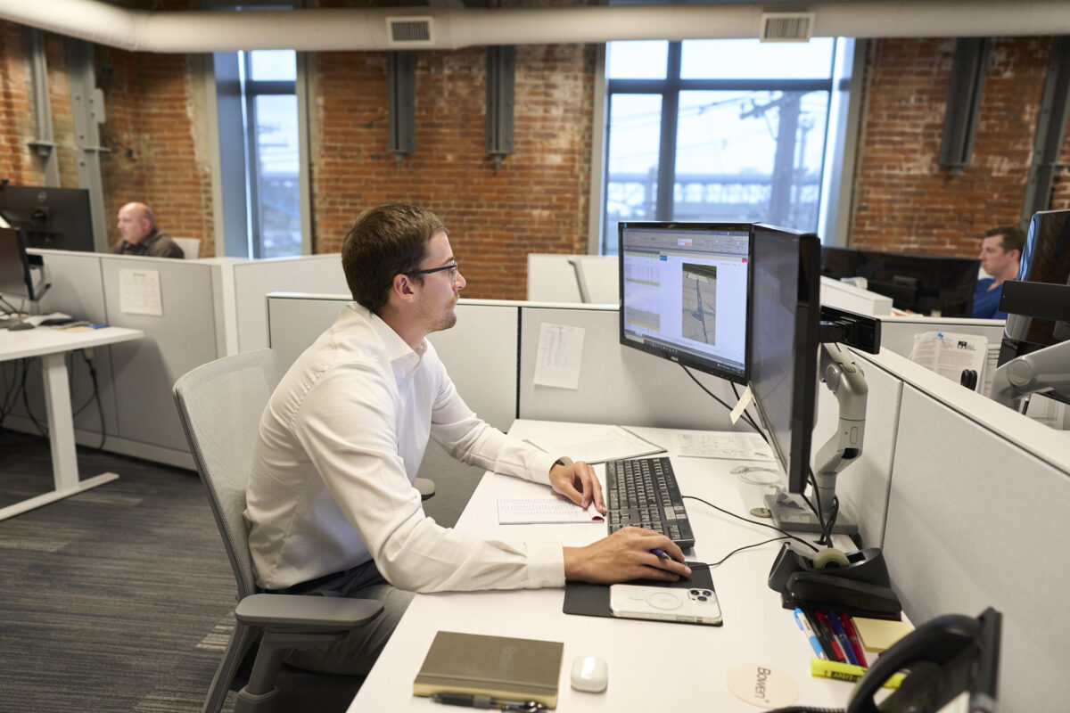 person working at computer with others working in background